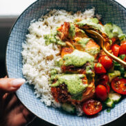 Salmon with basil sauce, tomato salad, and rice in a bowl