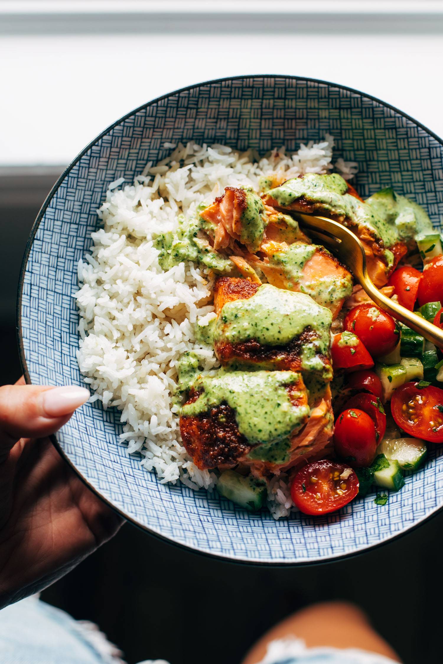 Salmon with basil sauce, tomato salad, and rice in a bowl