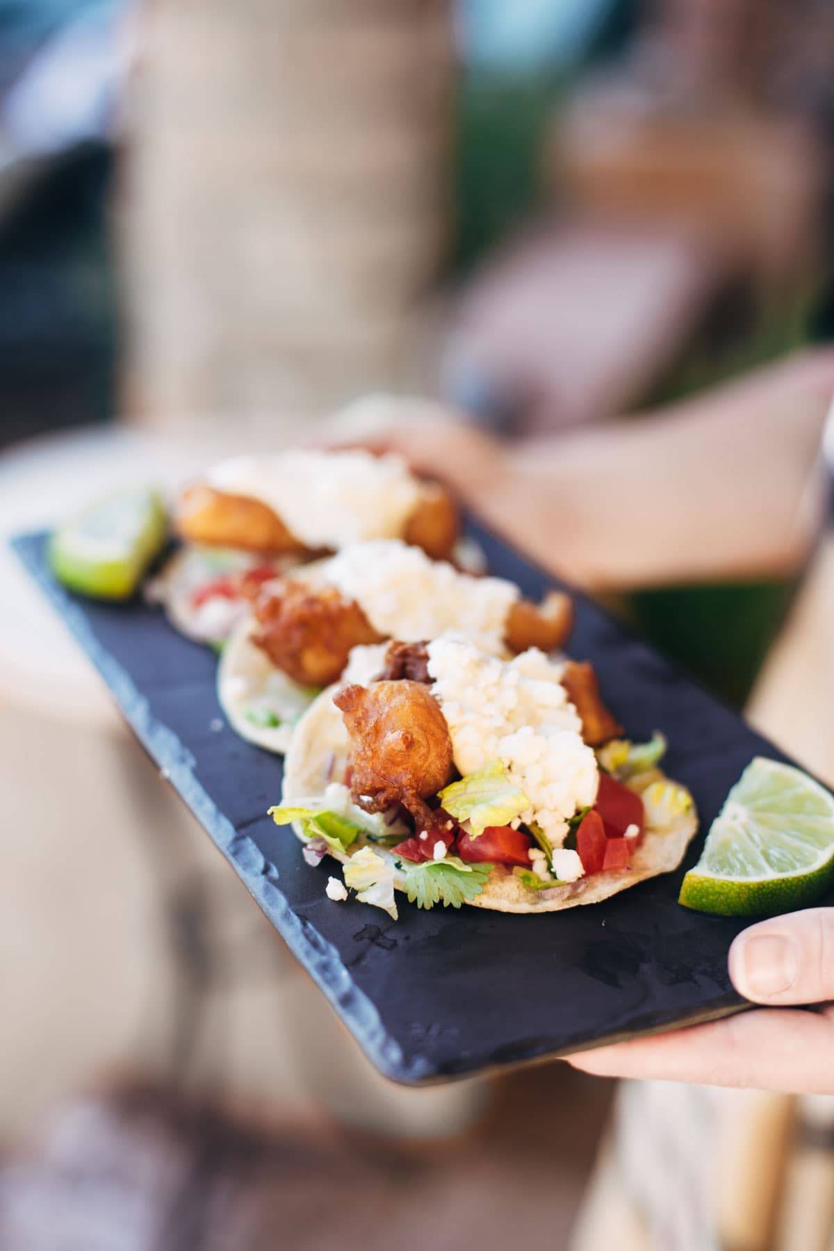 fish tacos on a tray with limes