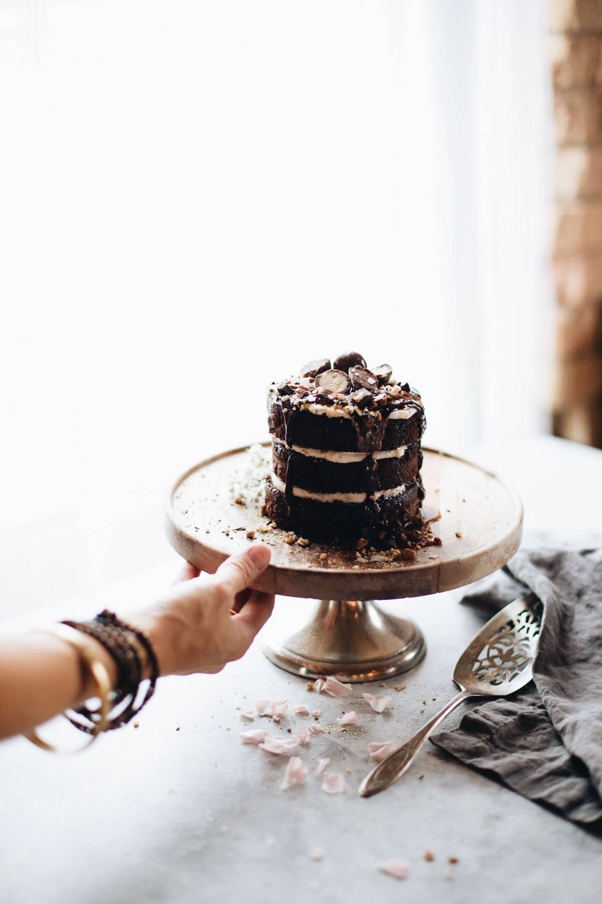 Small chocolate cake on a cake stand.