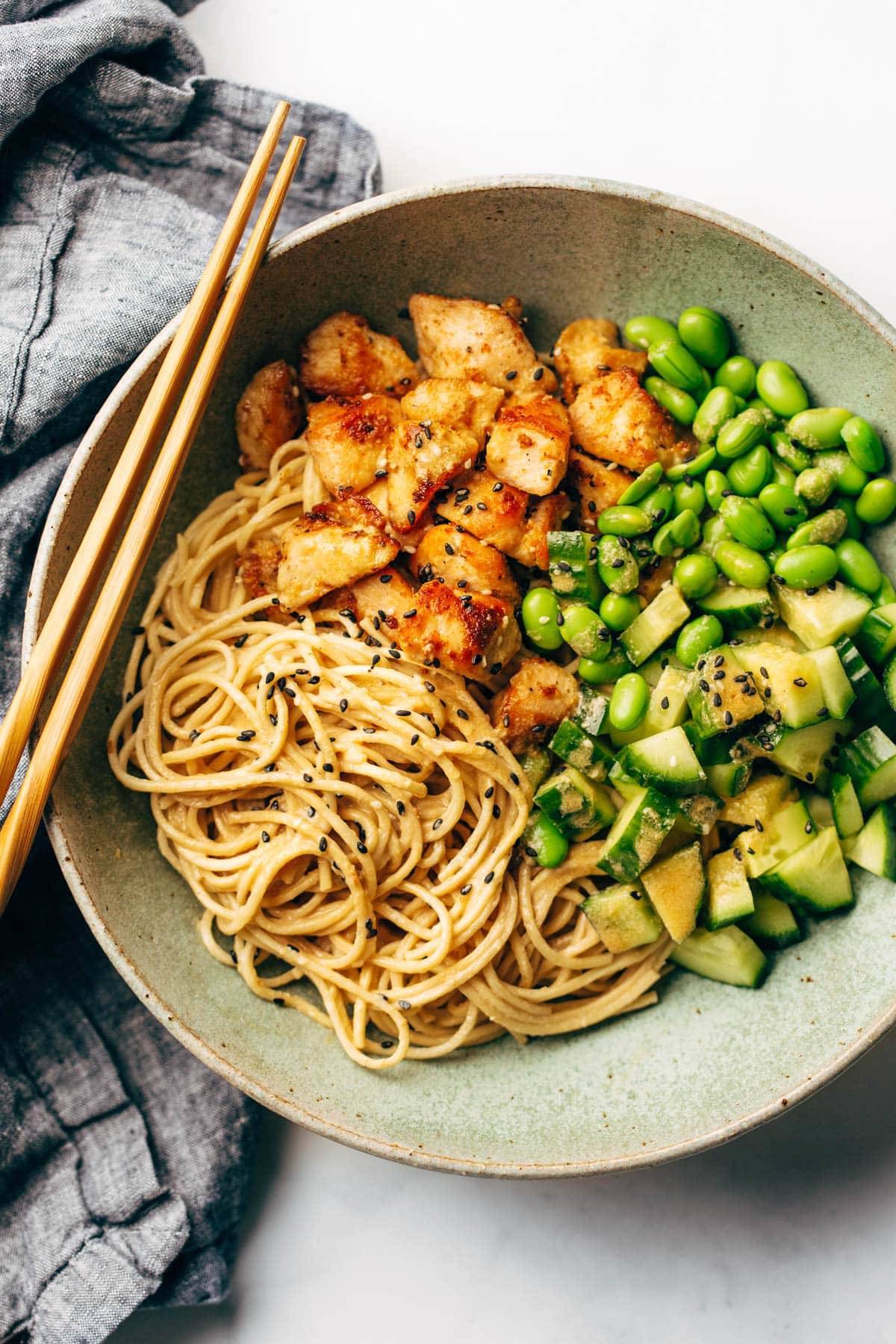 Sauteed chicken, edamame and cucumber over a bed of spaghetti.