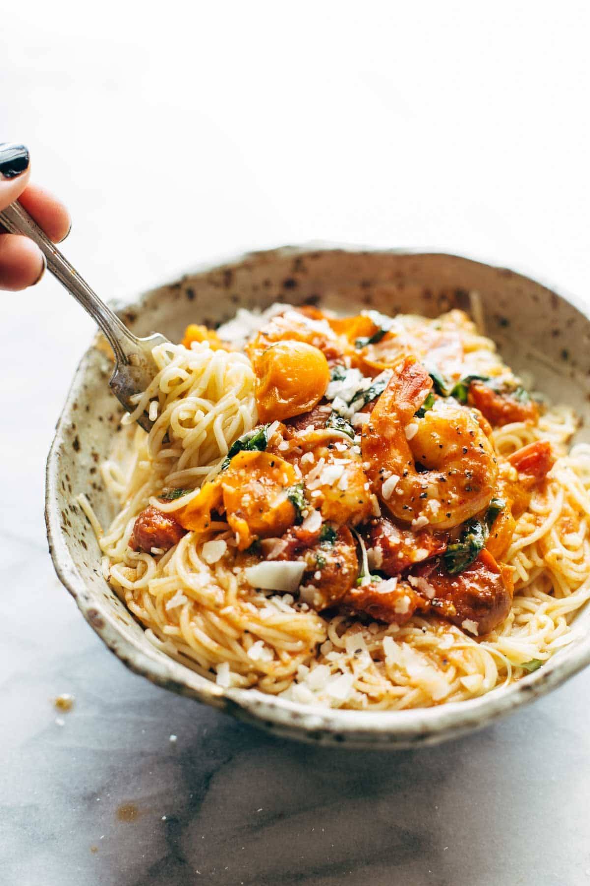 Capellini pomodoro with shrimp in a bowl with a fork.