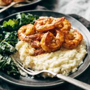 Spicy shrimp on a plate with cauliflower mash and kale.