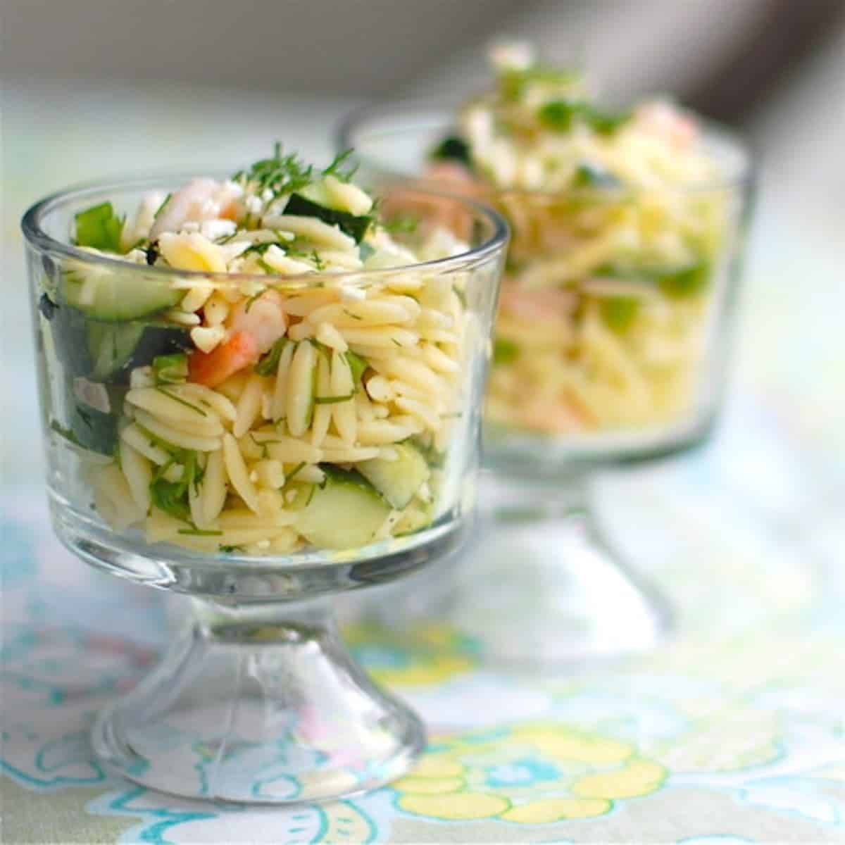 Shrimp and feta orzo in two glass dishes.