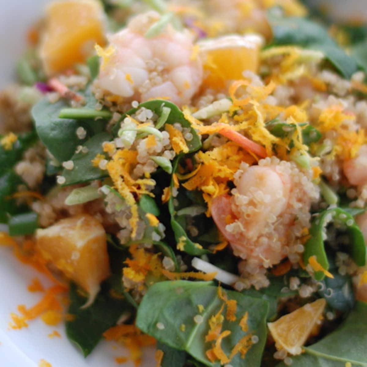 This shrimp and quinoa salad is super healthy, bright, and colorful. Fresh spinach, sauteed shrimp, quinoa, orange zest, and Asian dressing. | pinchofyum.com