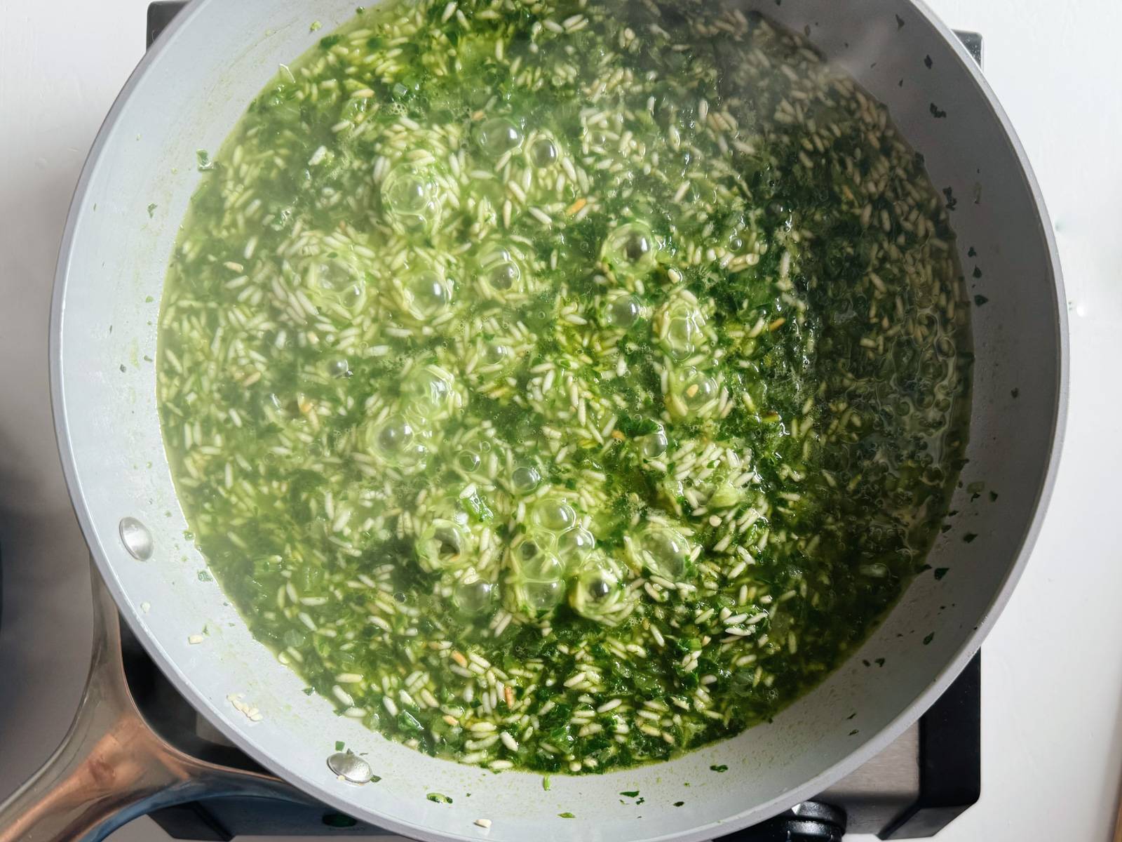 Cooking the rice and minced greens for green rice