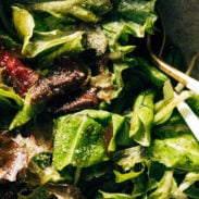Close-up of green salad with salad tongs