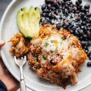 Sofritas Casserole on a plate with black beans and avocado.