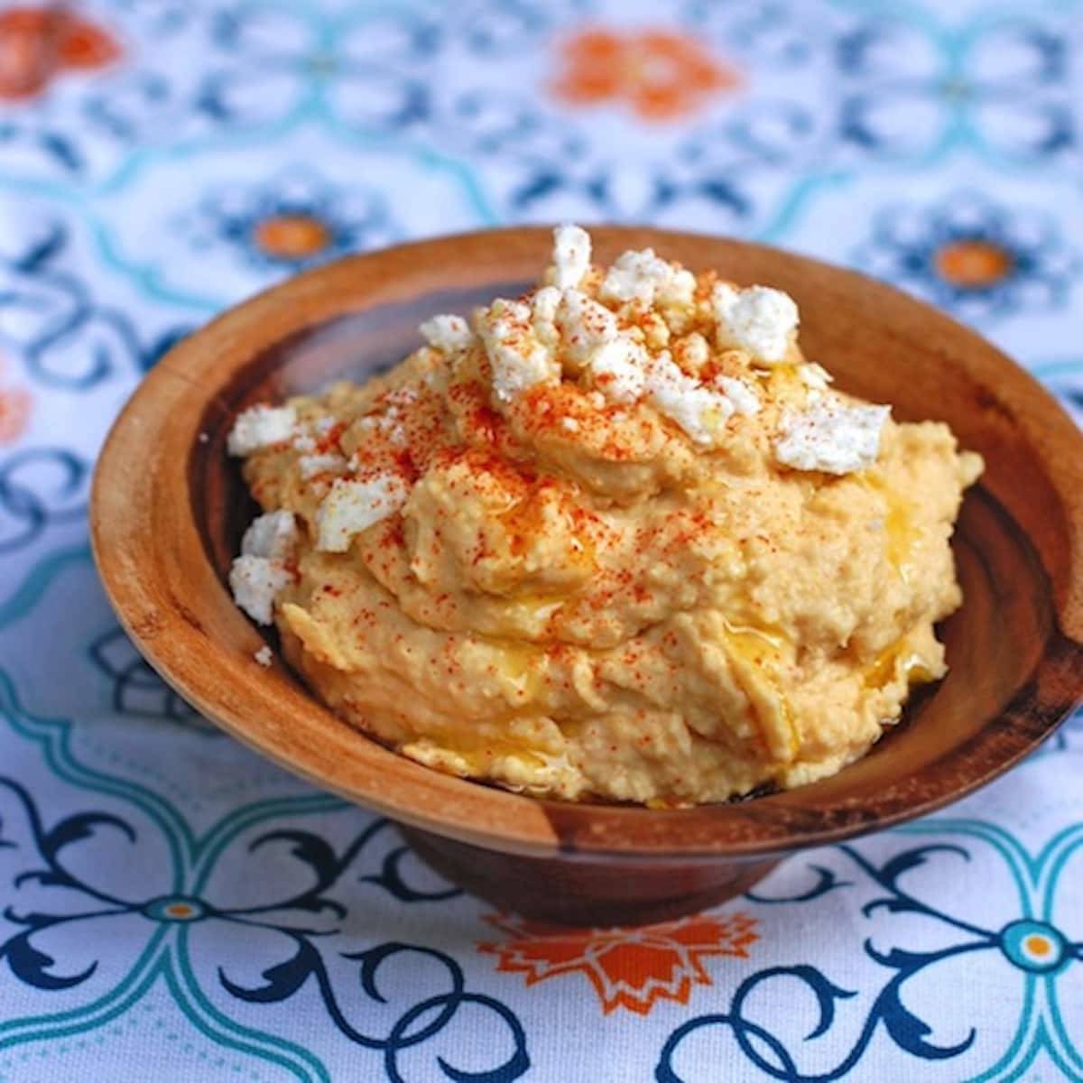 Spicy hummus topped with crushed red pepper, feta cheese, and olive oil. 