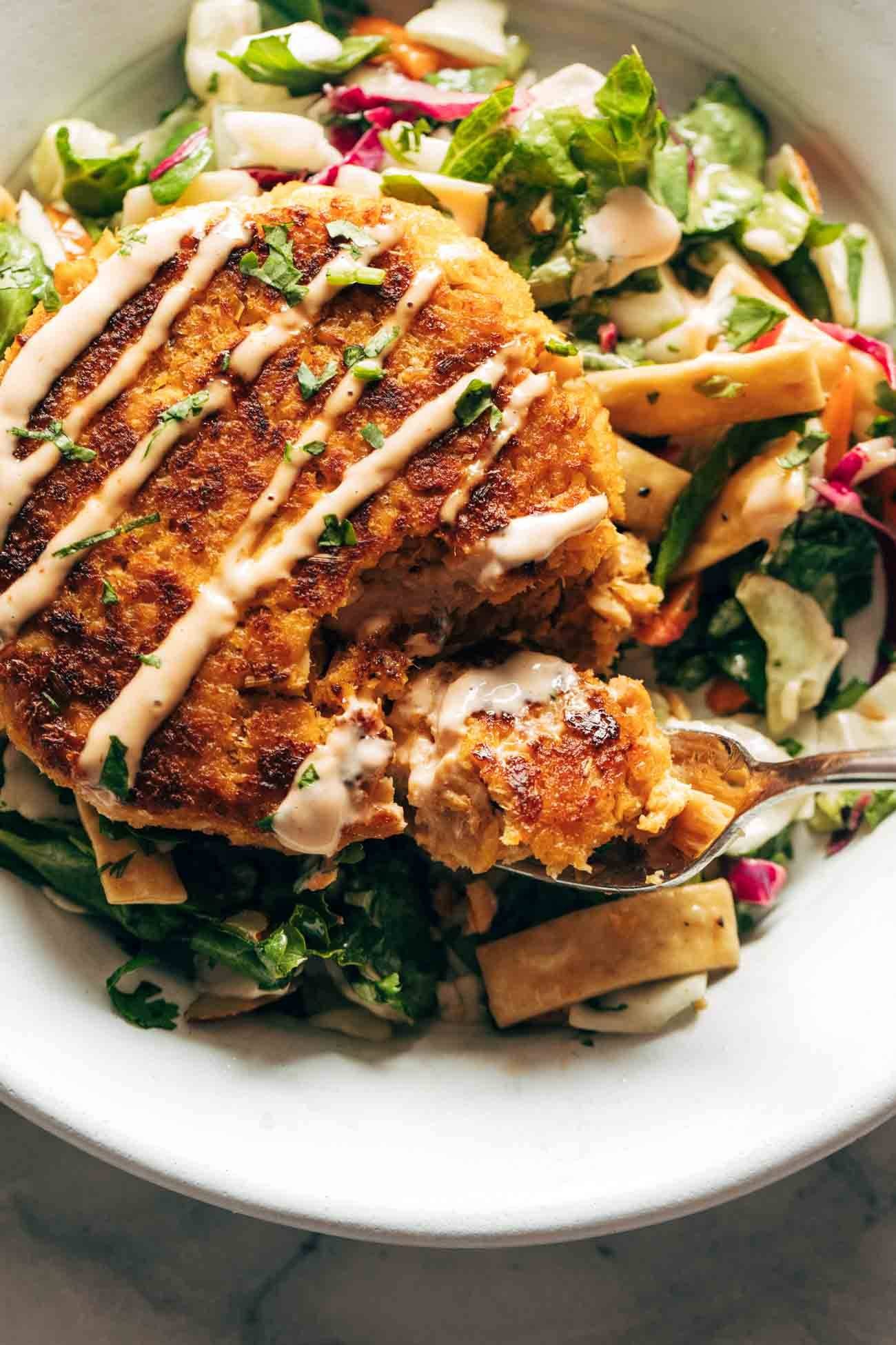 Salmon burgers on a bed of Mixed Greens in a bowl.