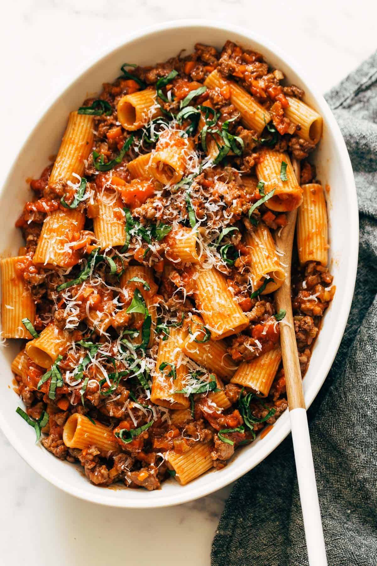 Spicy Sausage Rigatoni in a serving dish with wooden spoon.