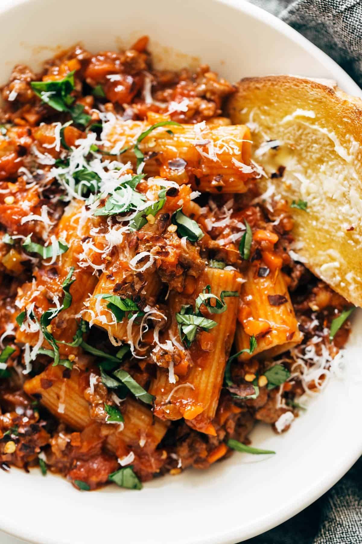 Spicy Sausage Rigatoni in a bowl with bread.