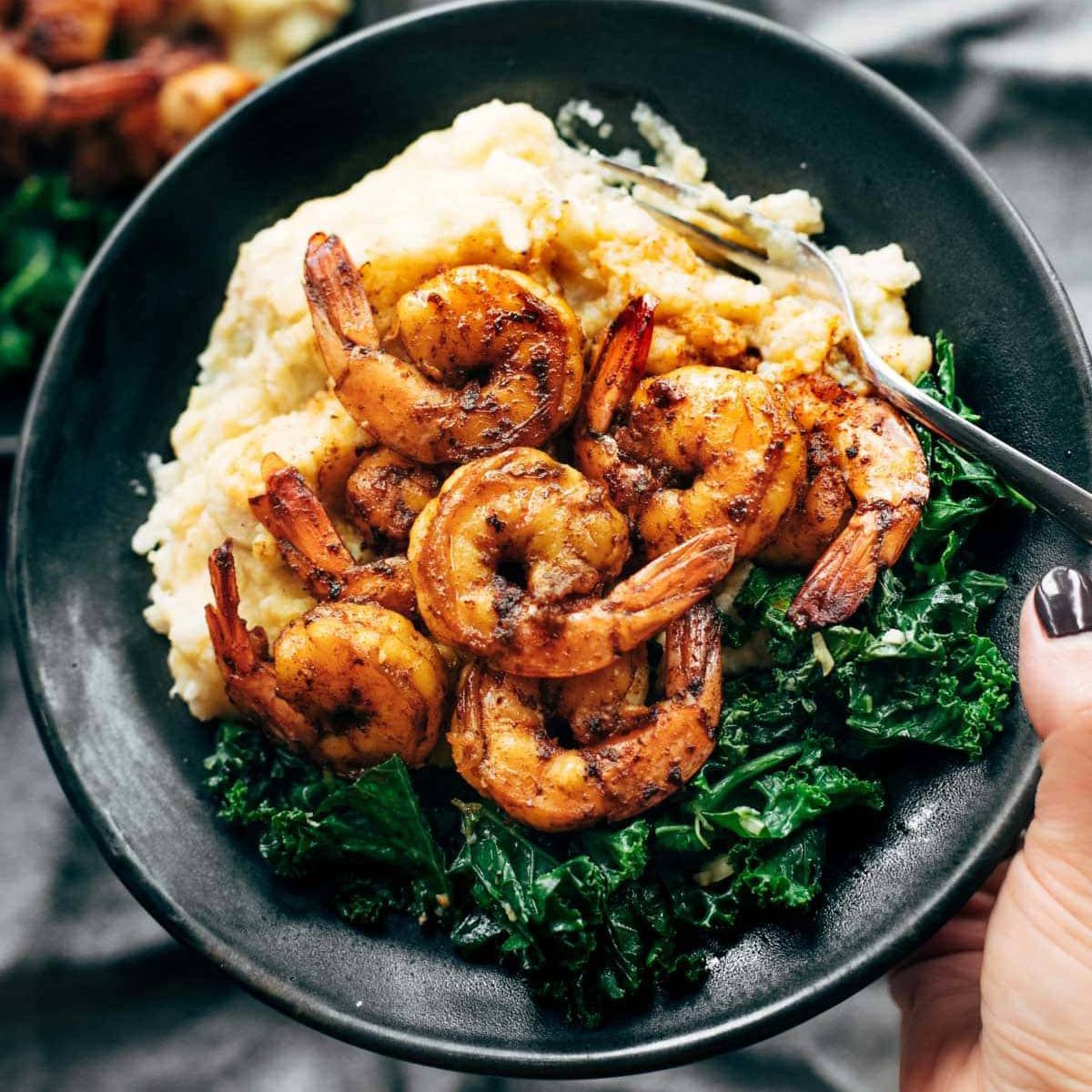 Shrimp and kale in a bowl with cauliflower mash.