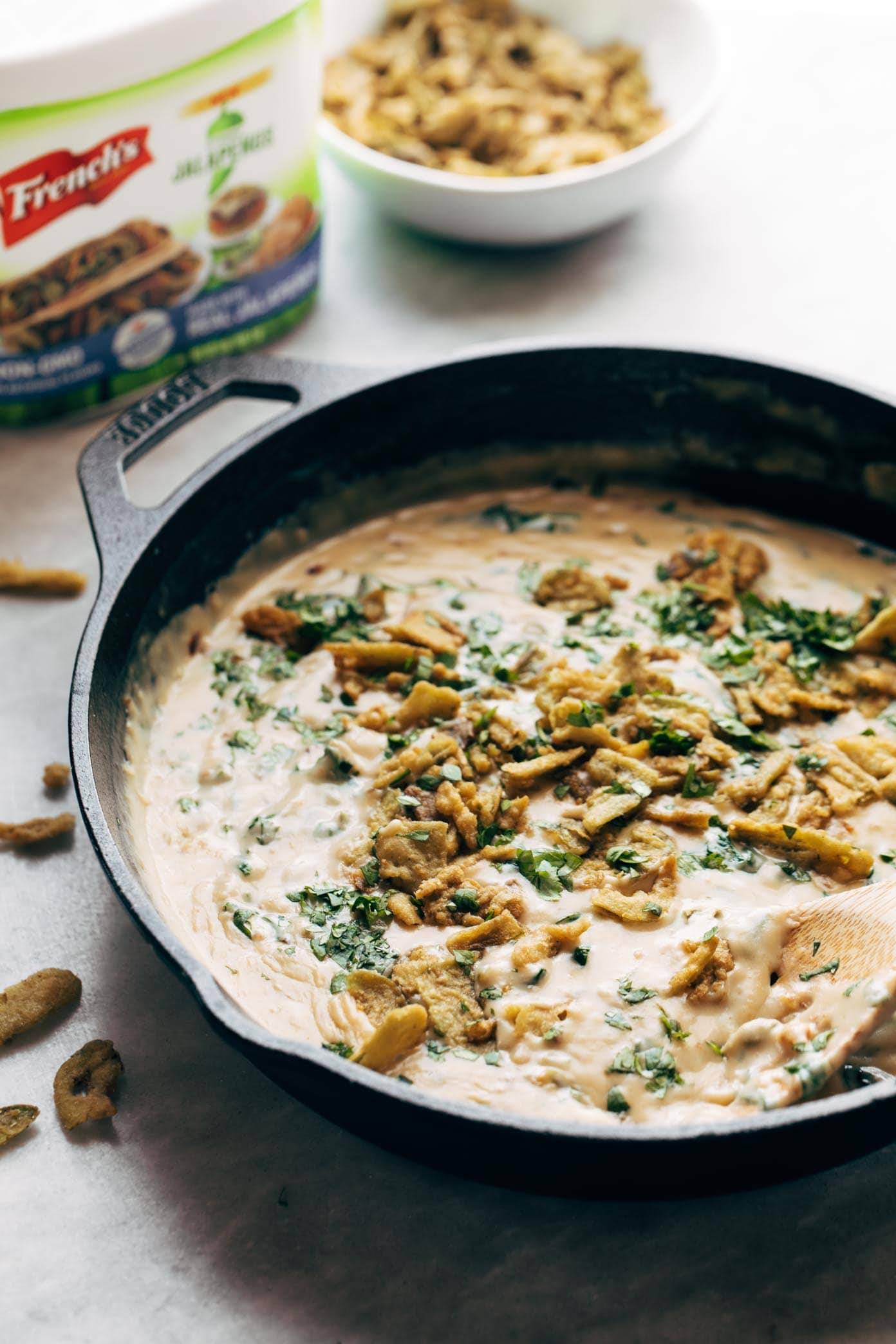 Spinach Queso in a skillet with crispy jalapeños 