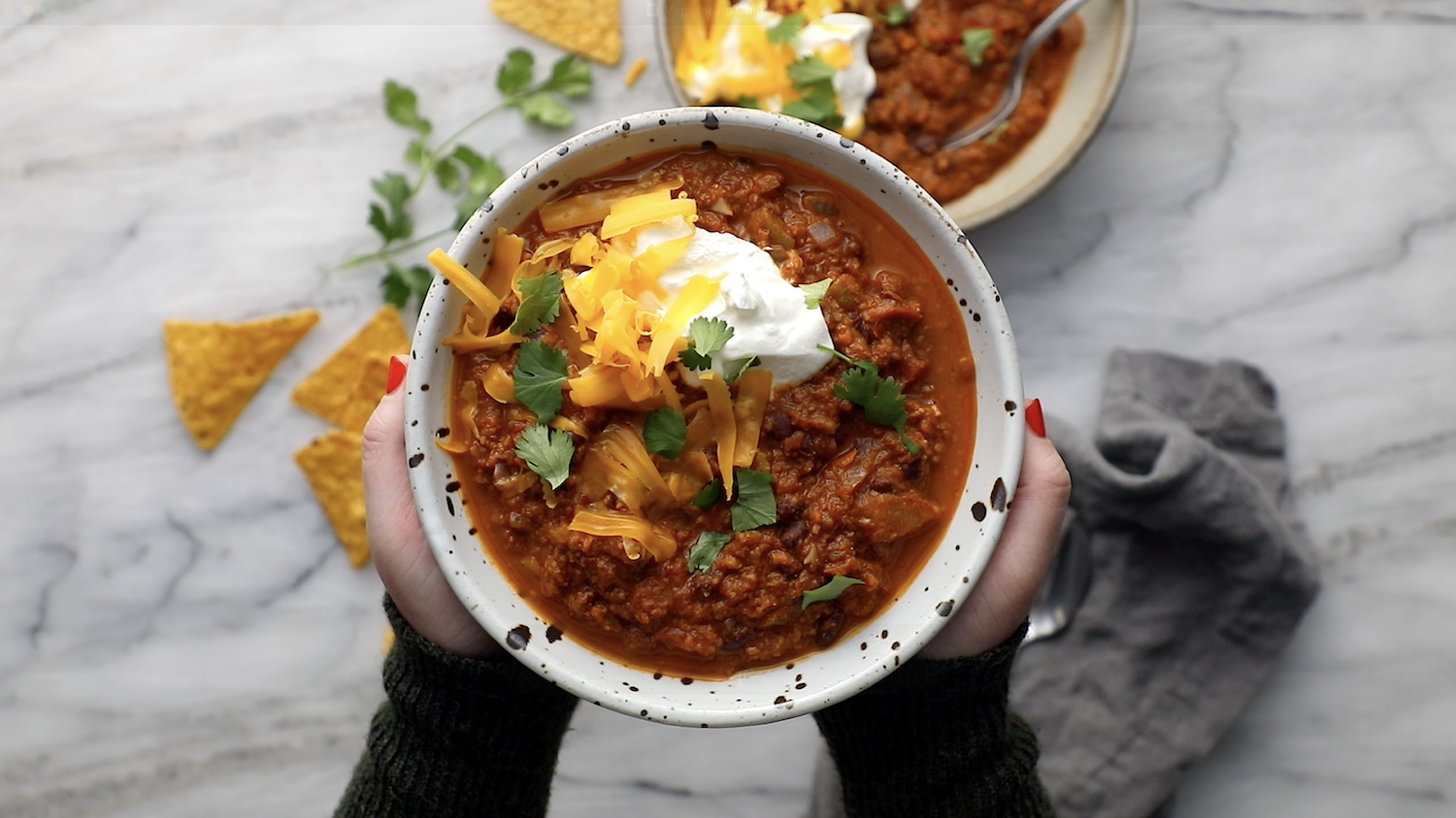 Bowl of vegetarian chili with toppings.