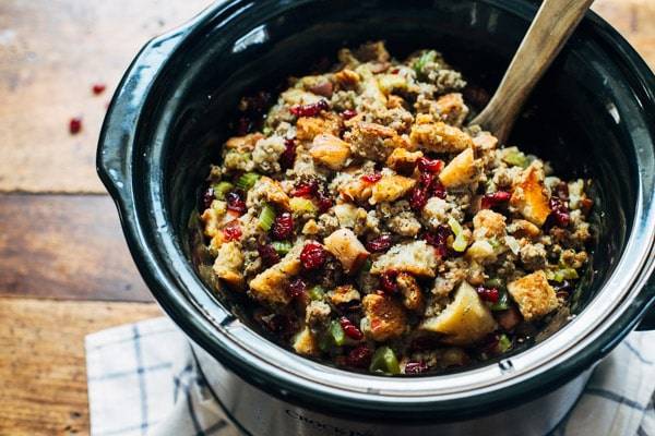 Slow cooker filled with pear and sausage stuffing.
