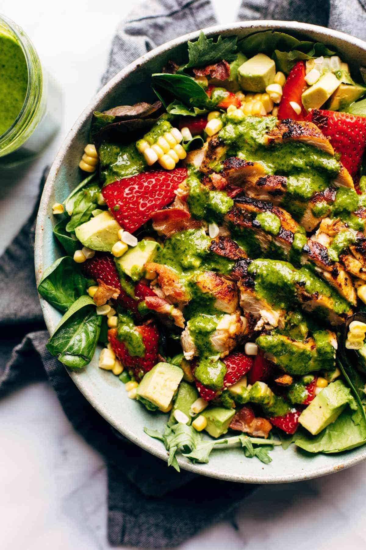 Summer Chipotle Chicken Cobb Salad in a bowl with dressing.
