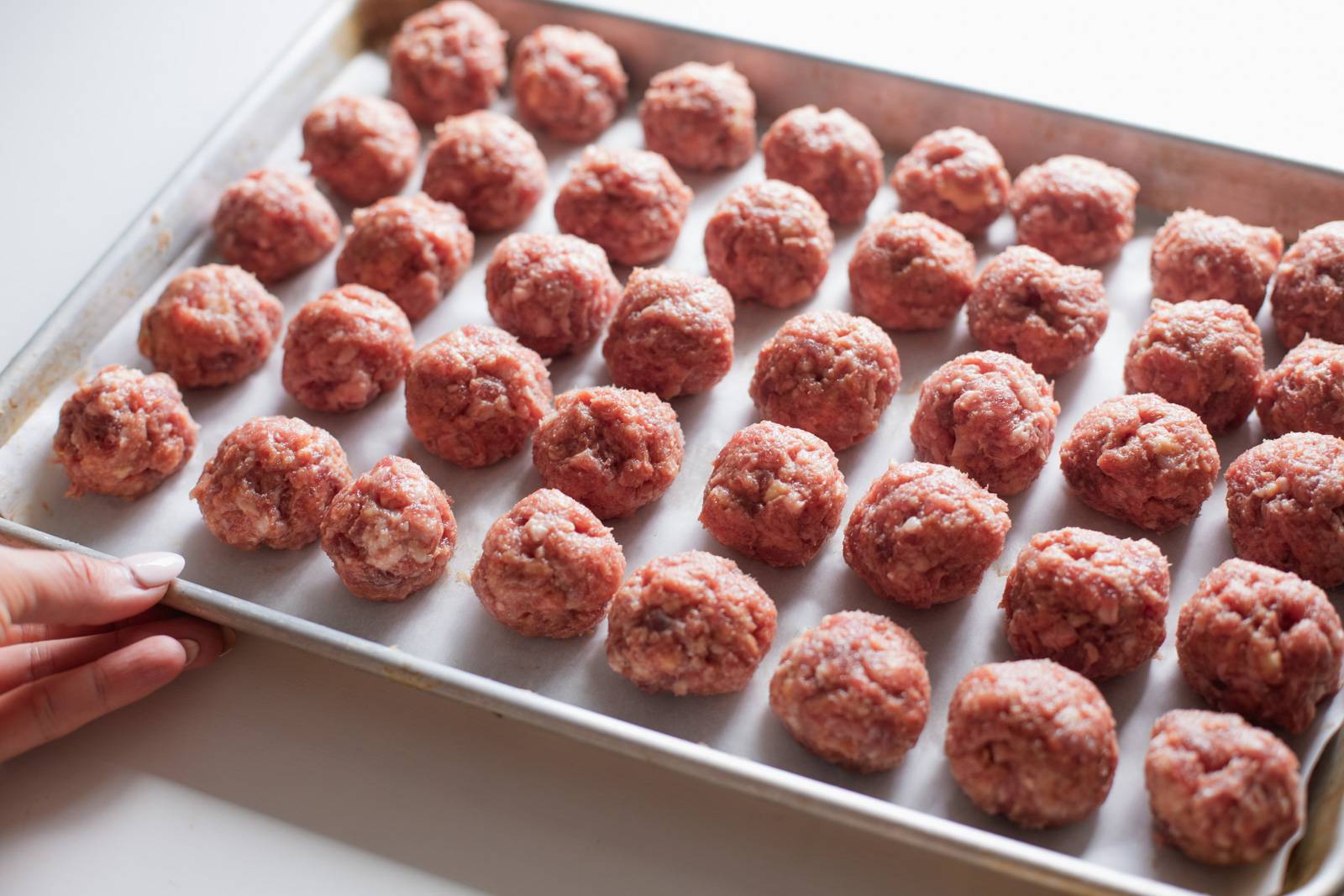 Rolled meatballs on a sheet pan.