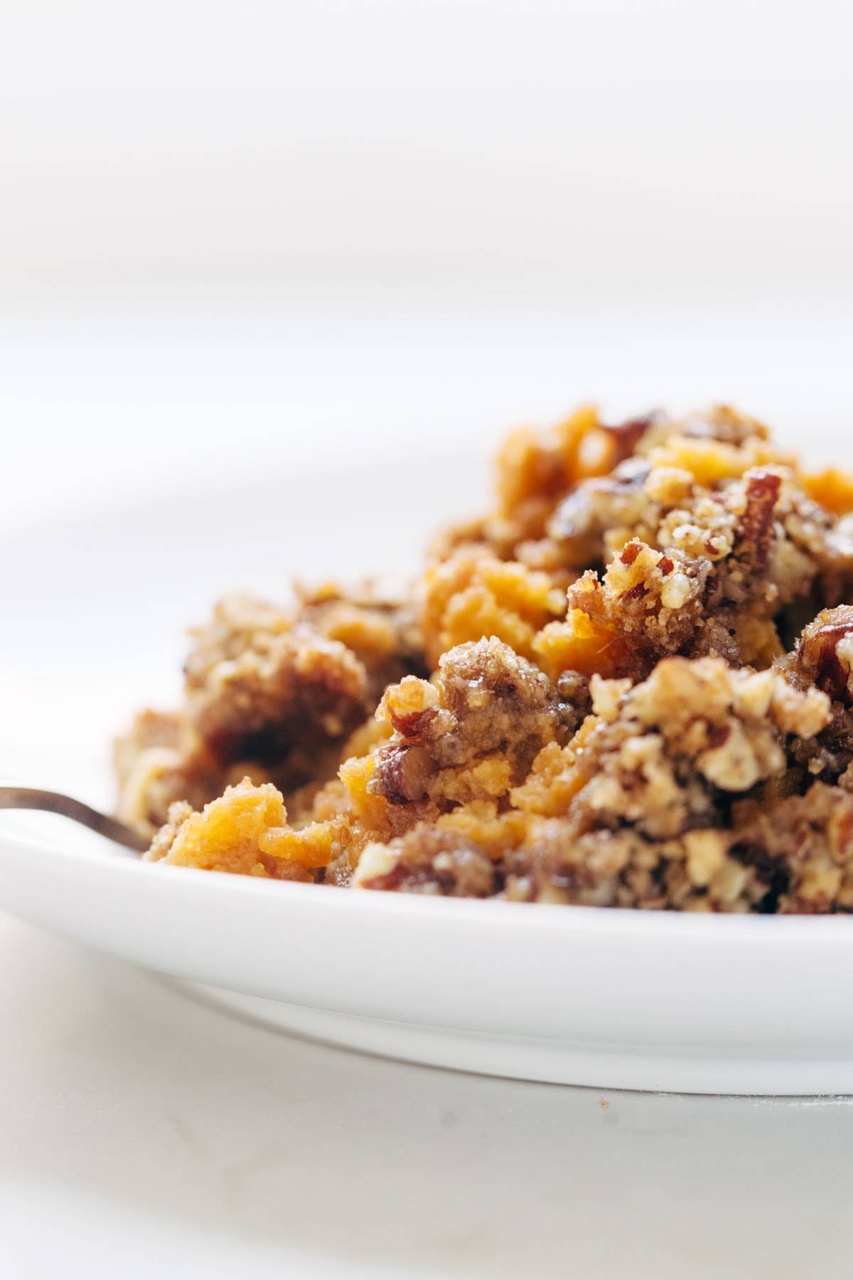 Sweet Potato Casserole with a crunchy brown sugar topping in a bowl with a fork