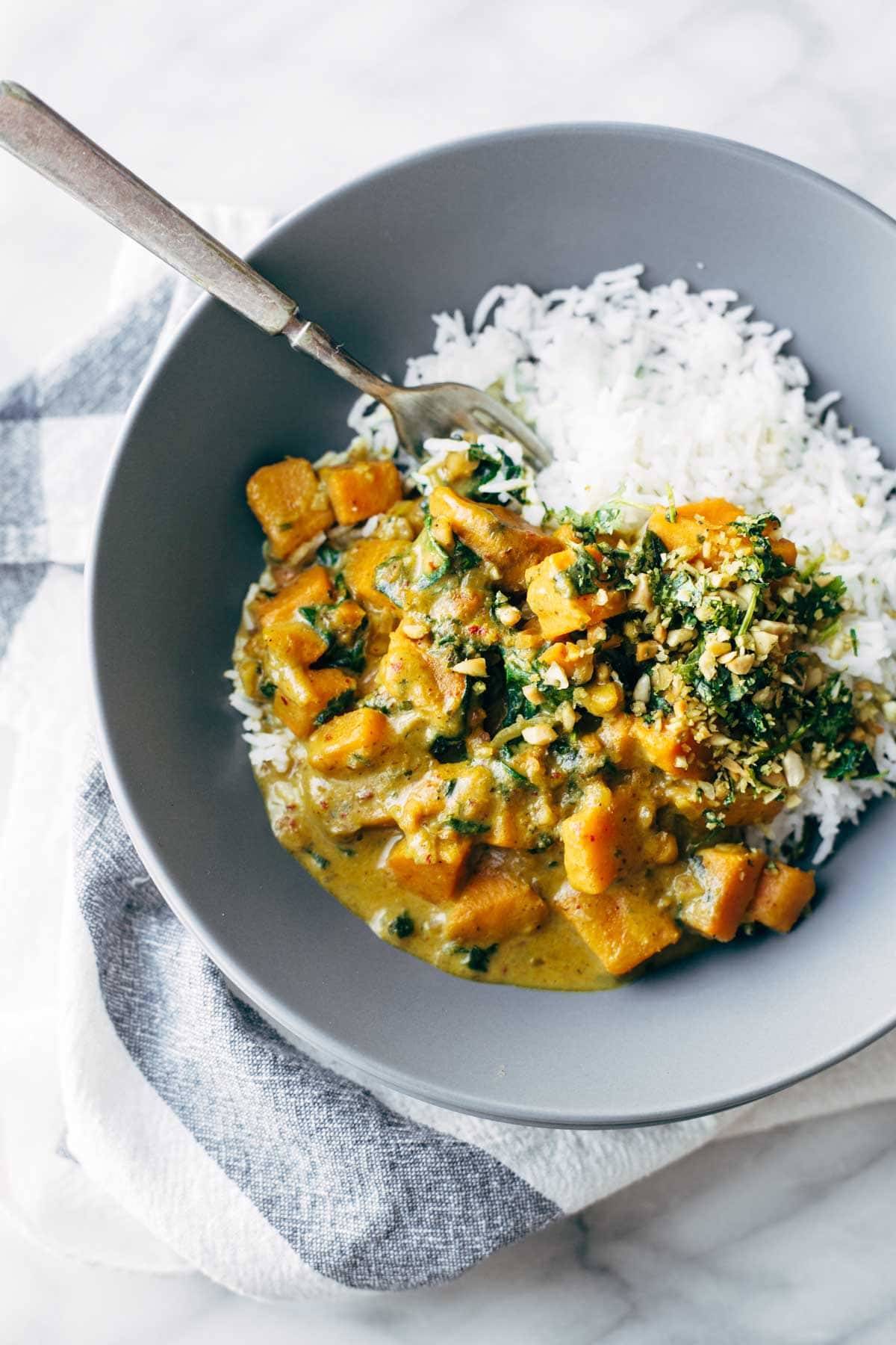 Creamy Thai Sweet Potato Curry with rice in a blue bowl.