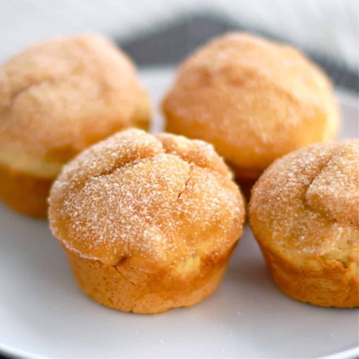 Four sugar-dusted sweet potato muffins.