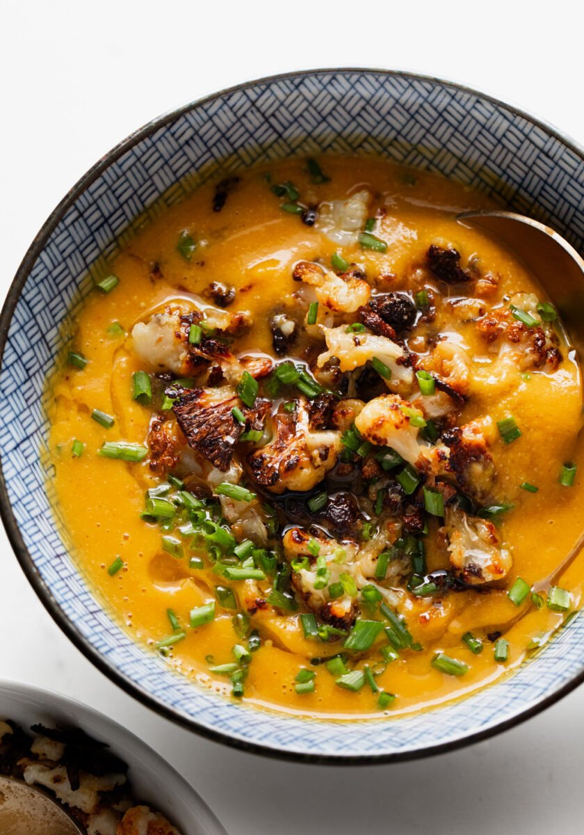 Sweet potato soup in a bowl topped with cauliflower crumbles.