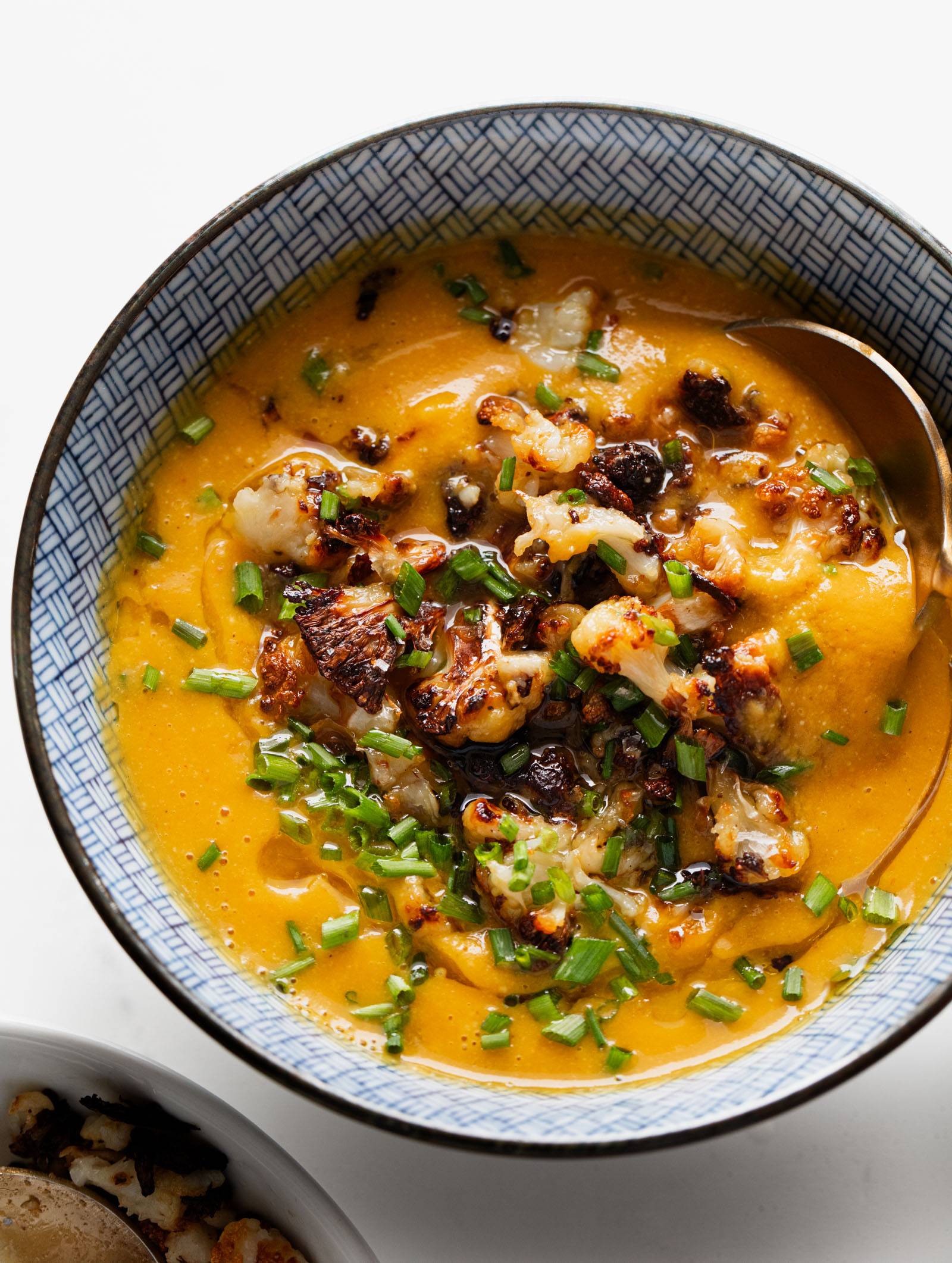 Sweet potato soup in a bowl topped with cauliflower crumbles.