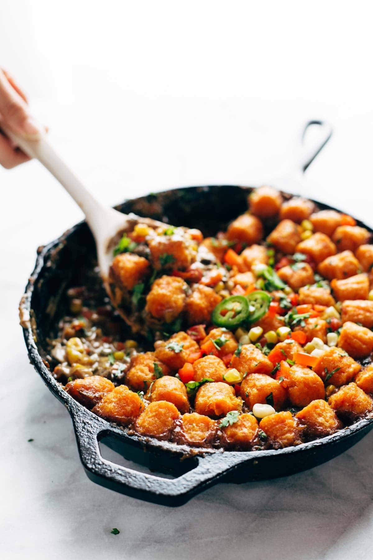 sweet potato tater tot hotdish with a wooden spoon