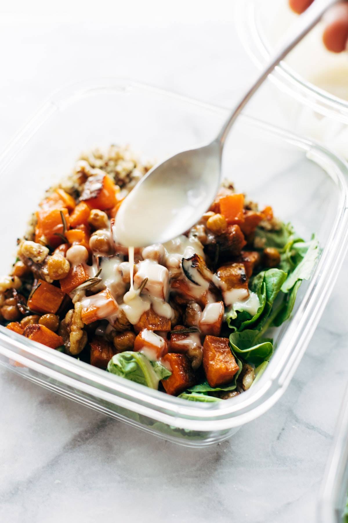 Drizzling dressing on quinoa sweet potato salad.