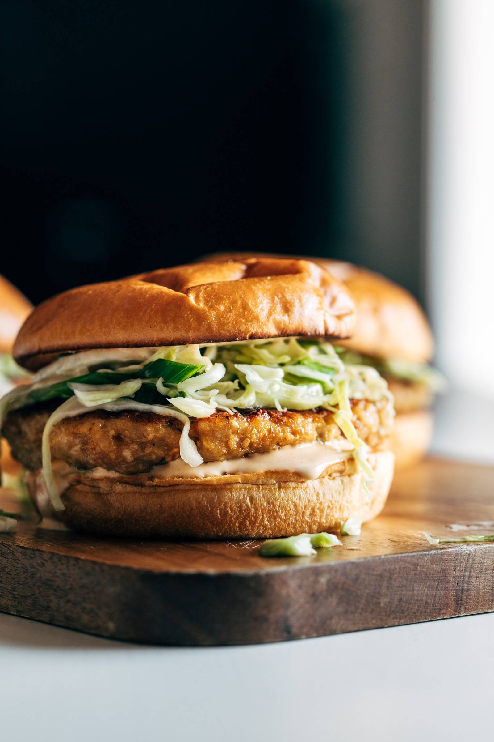 Close-up image of a chicken burger on a serving tray.