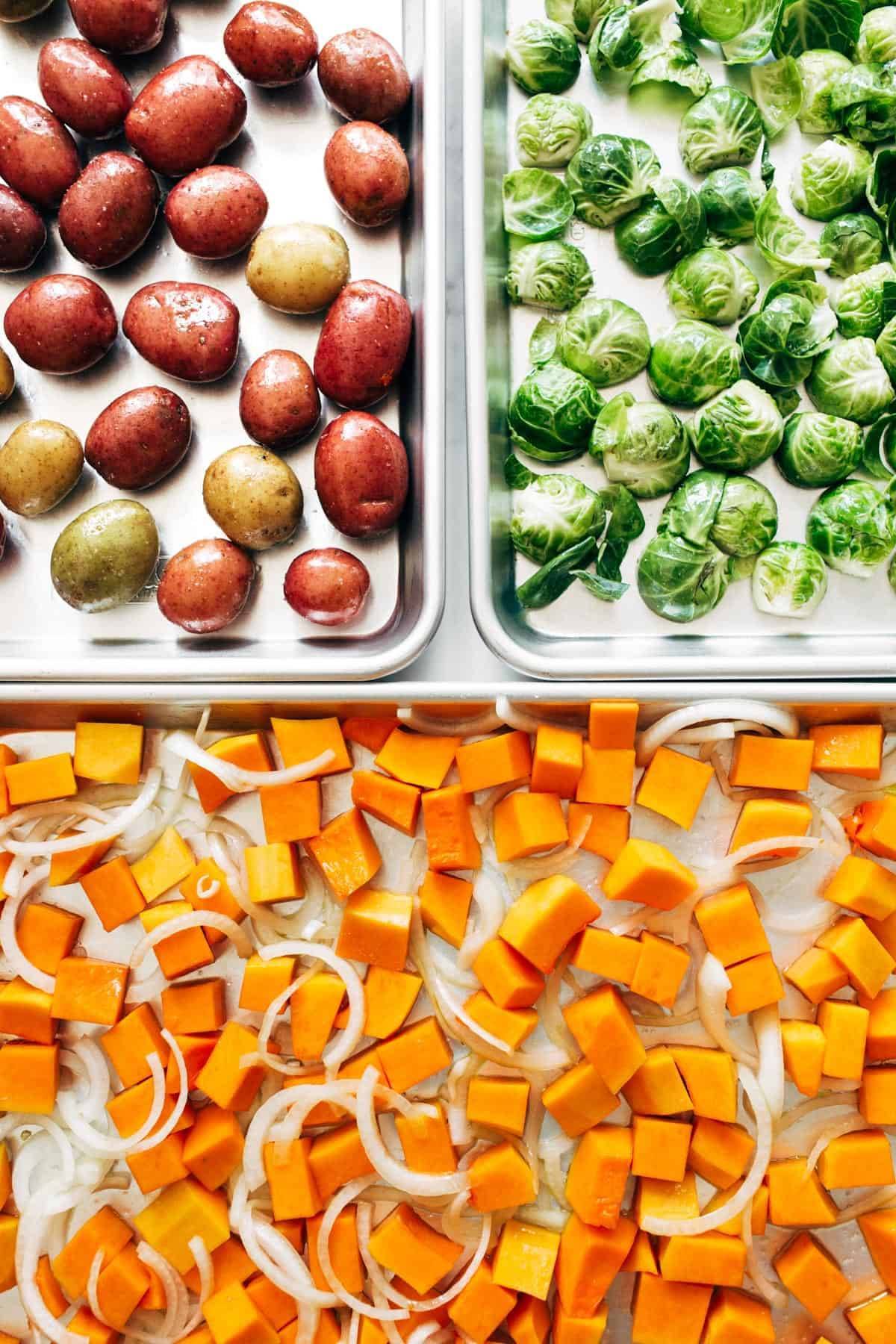 Potatoes, brussels sprouts, and squash on sheet pans.