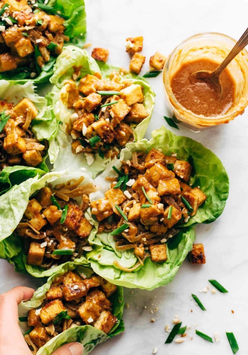 Firecracker Vegan Lettuce wraps in a row with hand.