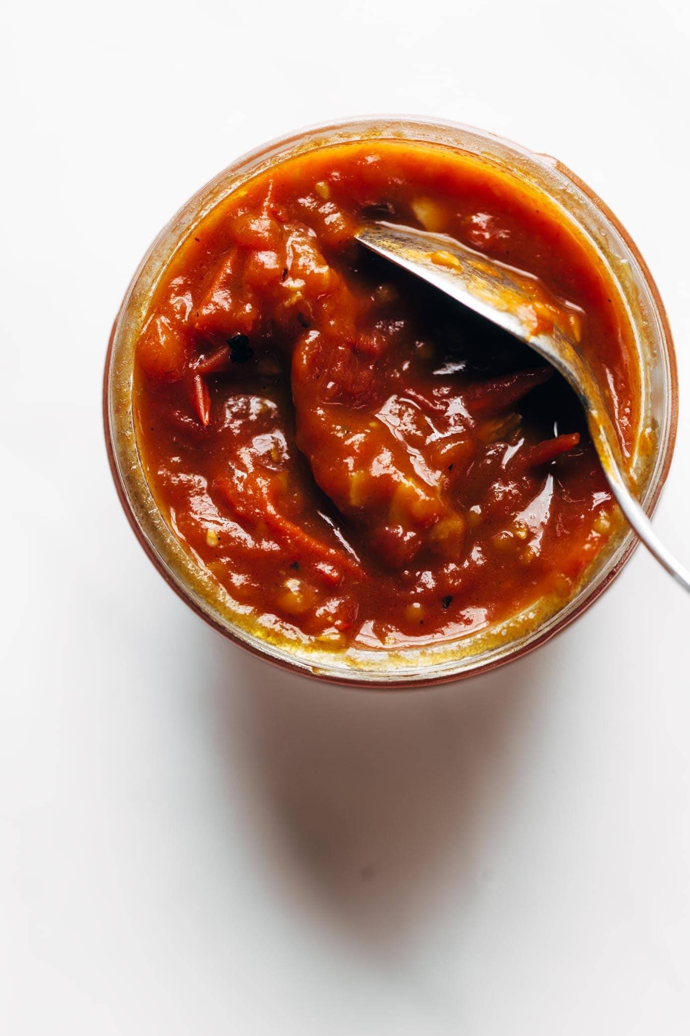 Basic Garlic Butter Tomato sauce in a jar with a spoon