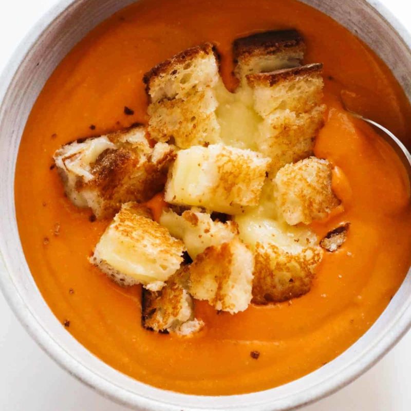 A bowl of tomato soup with the grilled cheese .