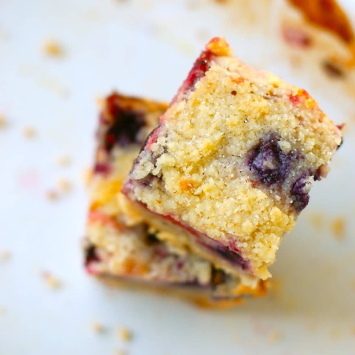 Triple berry pie bars stacked on each other.