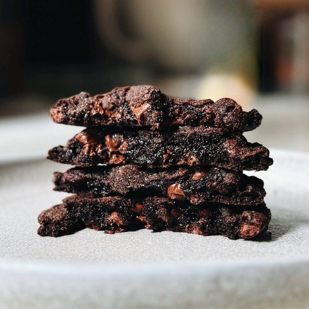 Chocolate cookies stacked on a plate.