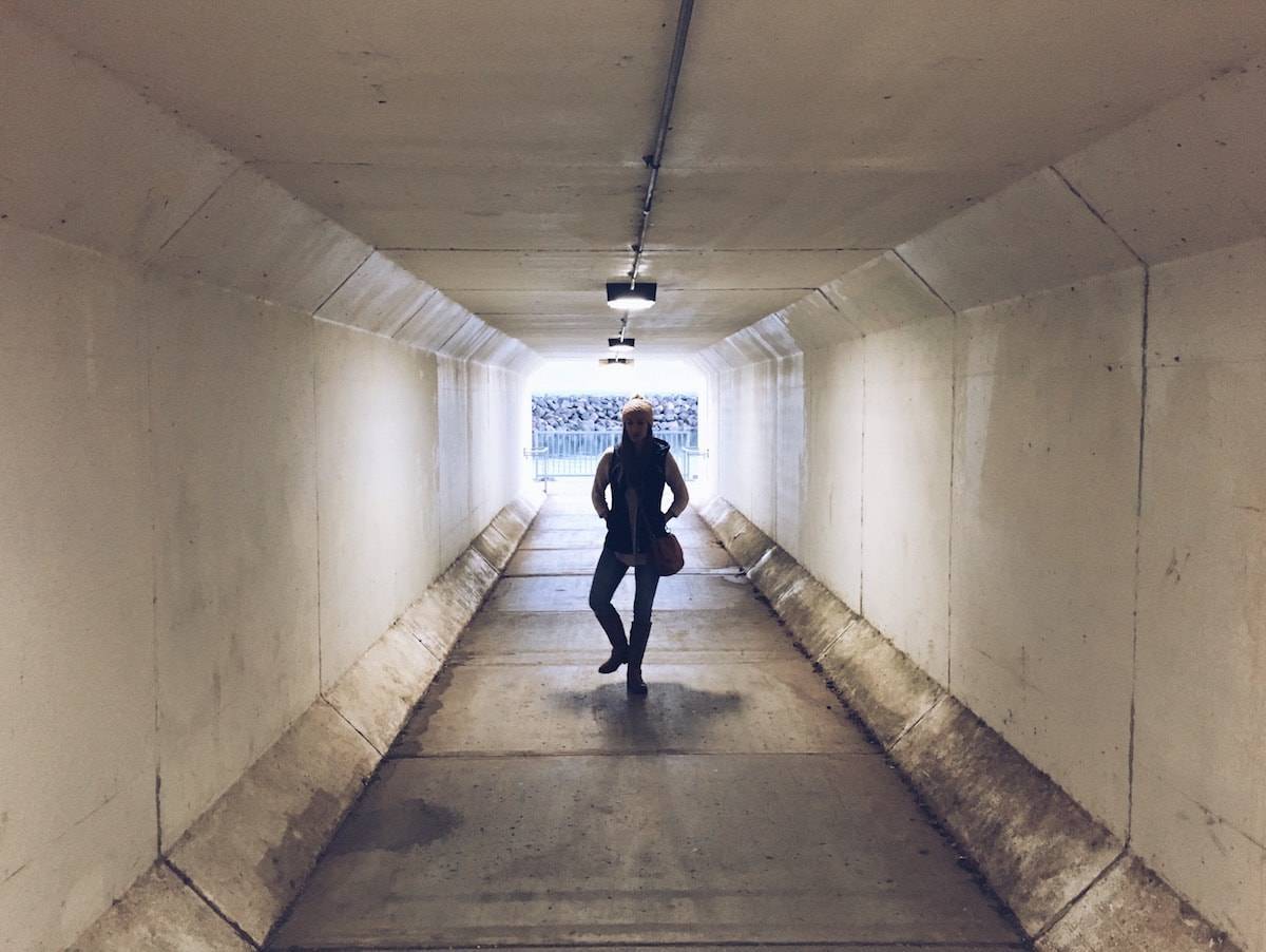 Woman standing in a tunnel.