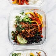 Vegan burrito bowls with rice in glass containers.