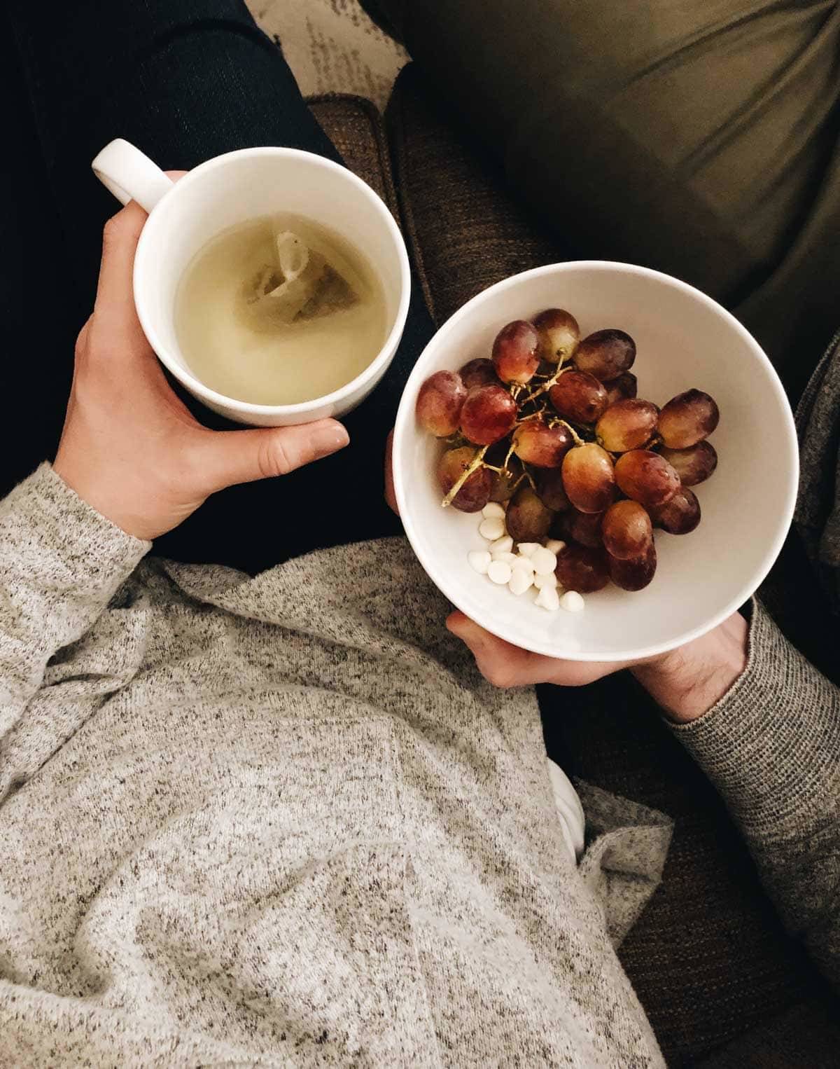 Mug of tea and bowl of grapes.