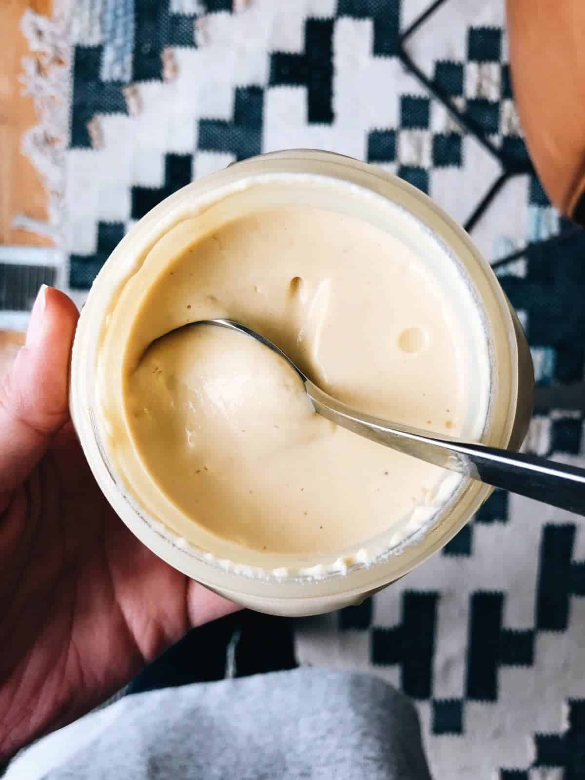 Vegan yogurt in a jar with a spoon.