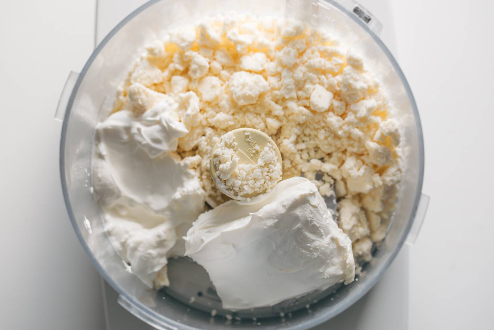 Ingredients for whipped feta in a food processor.