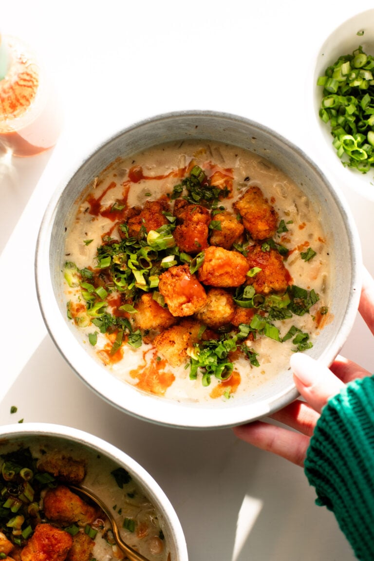 White chicken chili in a bowl with tots on top.