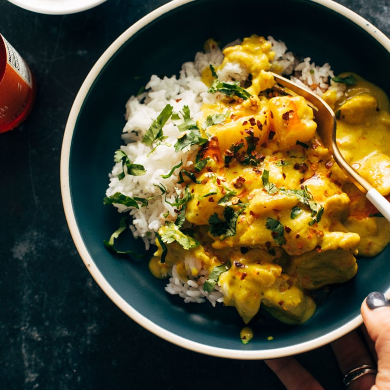 Yellow chicken curry in a bowl with a fork