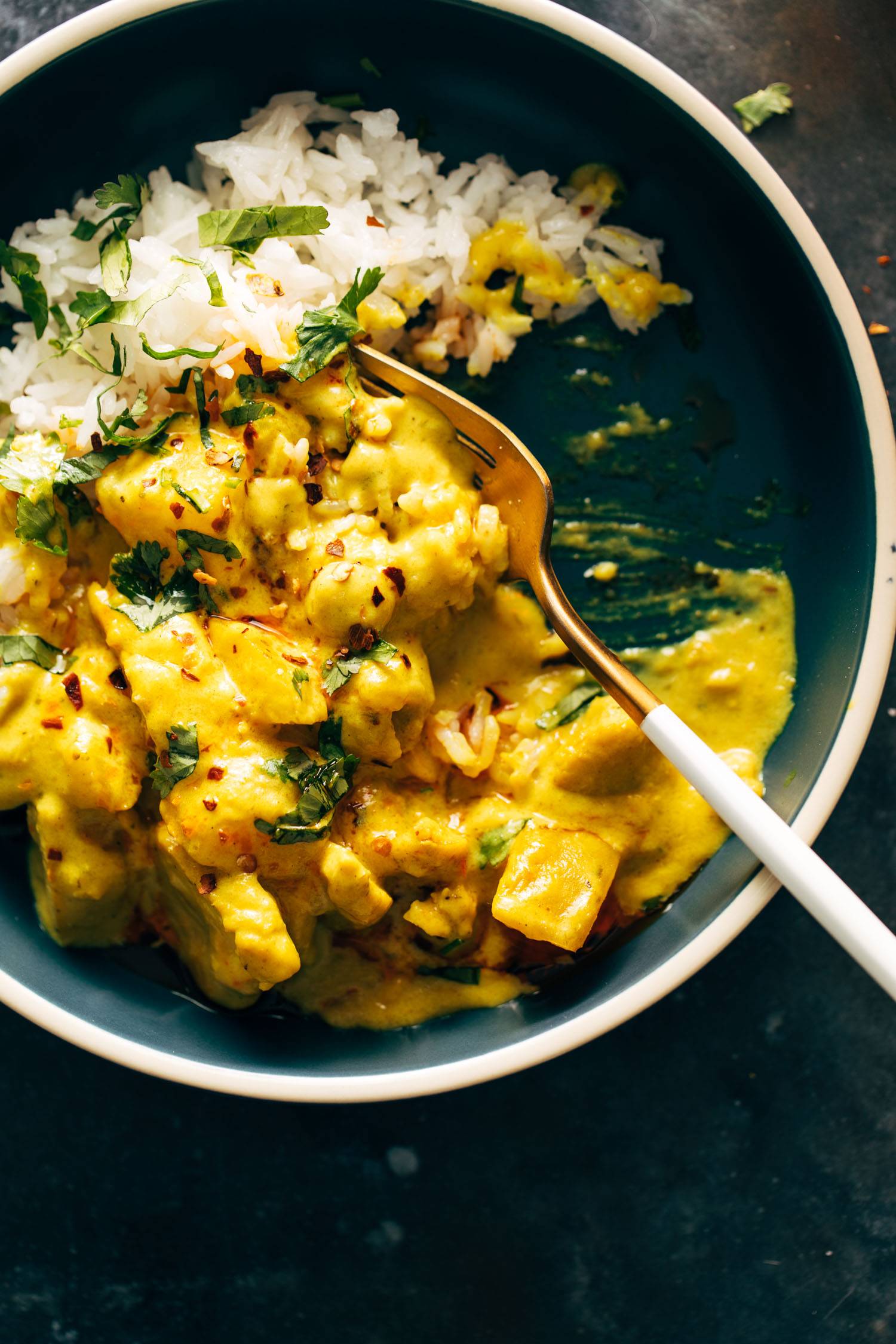 Yellow curry in a bowl with a fork