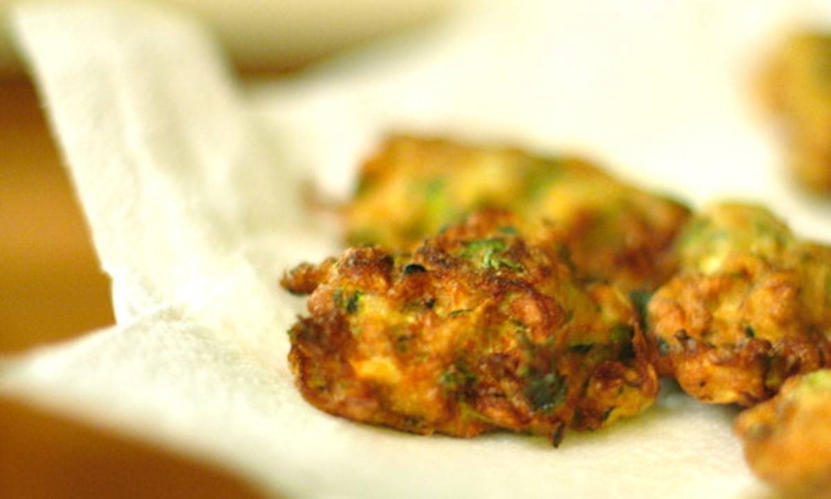 Zucchini Fritters with goal cheese sauce on a napkin.