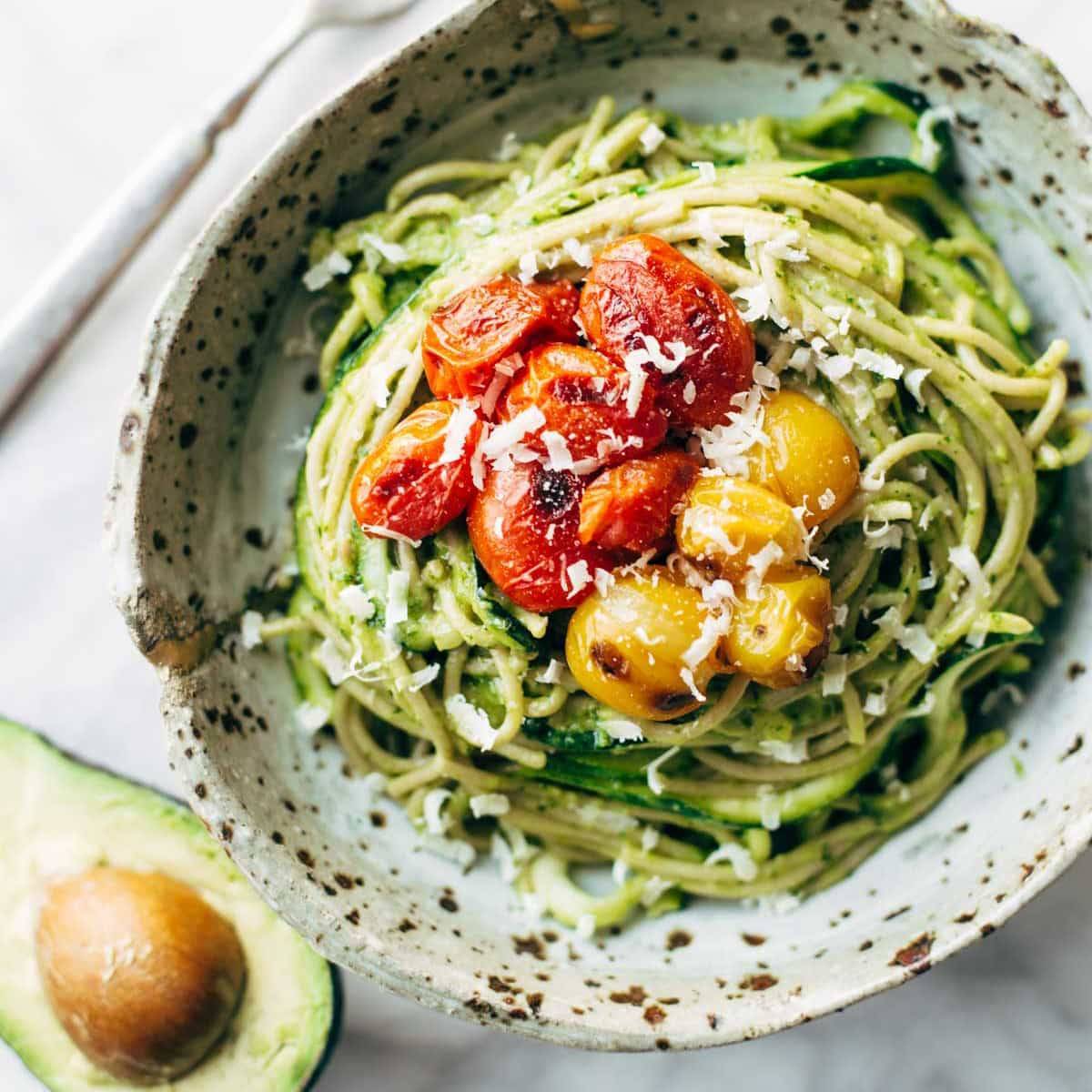 Burst Tomato and Zucchini Spaghetti with Avocado Sauce and a side of half an avocado.