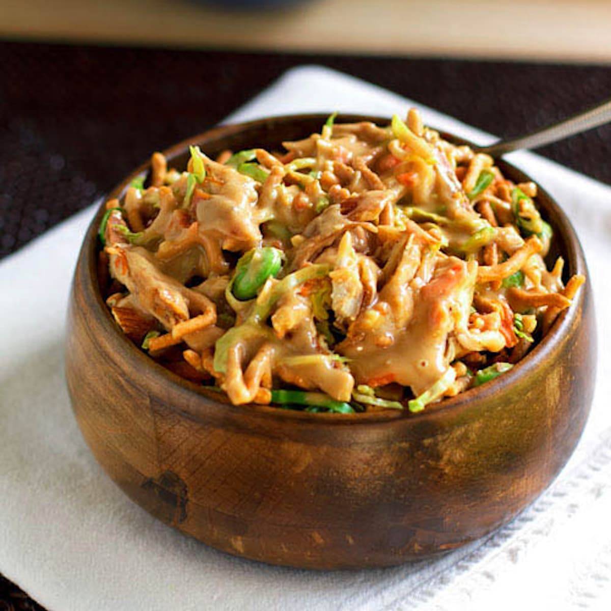 Asian chicken salad in a wooden bowl.