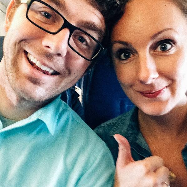 Man and woman smiling on a plane.
