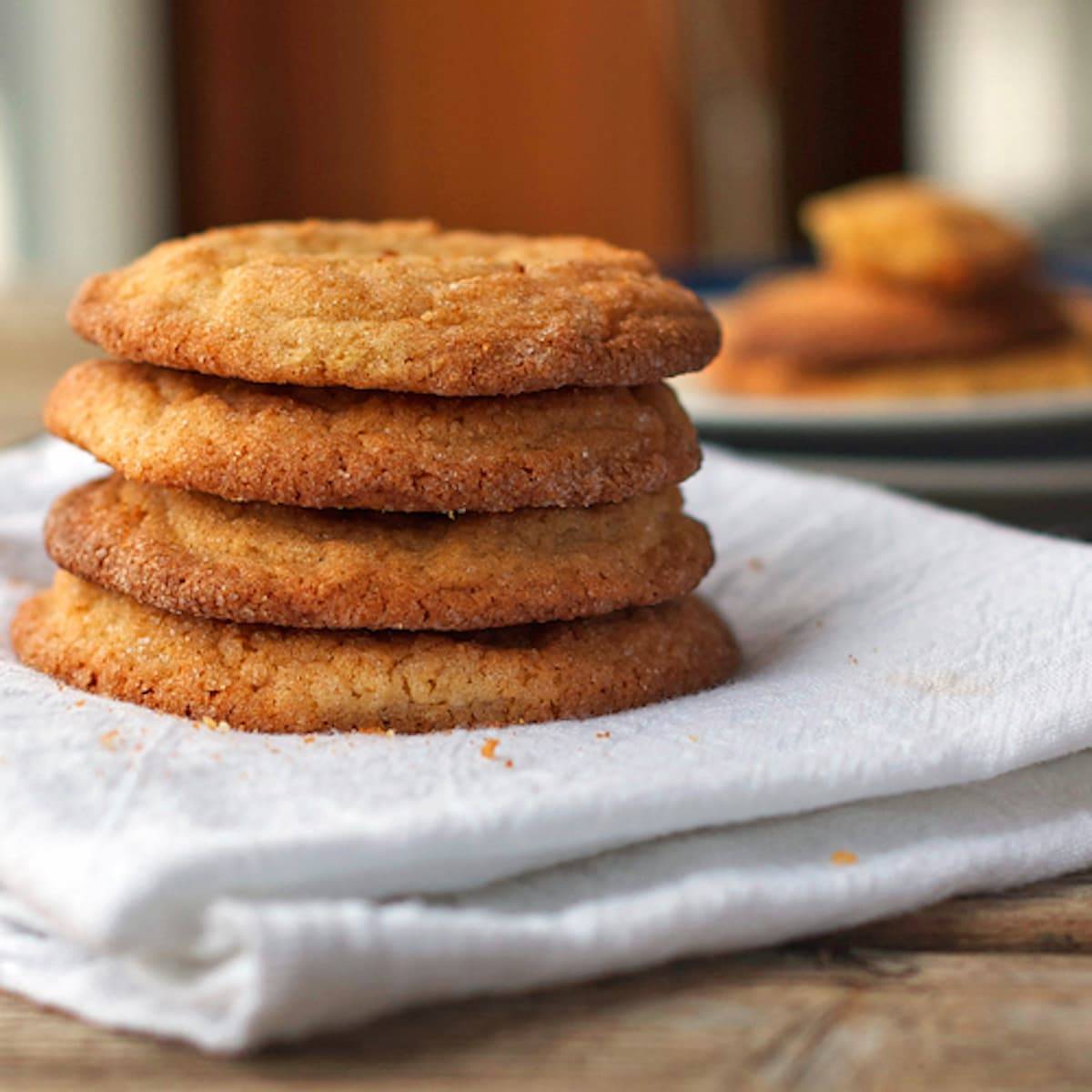 Brown sugar cookies stacked on each other on a white napkin.