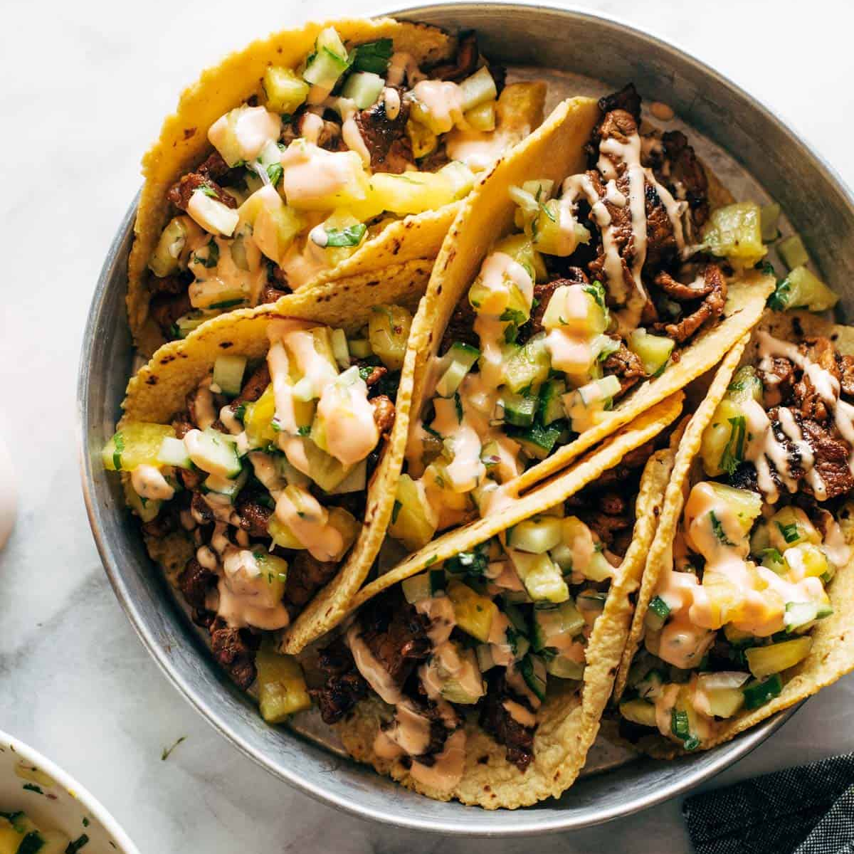 Four Caramelized Pork Tacos with Pineapple Salsa side by side in a bowl.